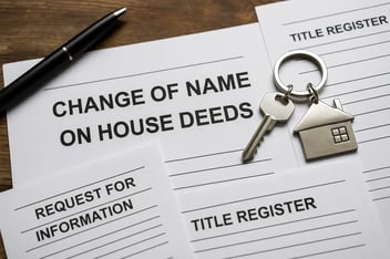 Form titled 'Change of Name on House Deeds' with a pen, house key, and documents on a wooden table, representing legal property paperwork.